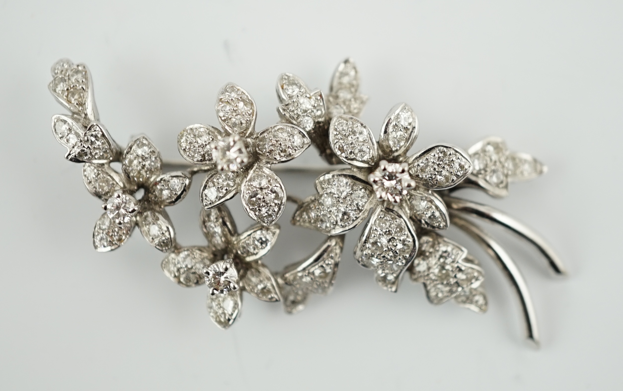 A late 1960's 18ct white gold and diamond cluster set floral spray brooch